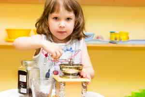 girl grinding coffee at kidz camp montessori - plano, tx